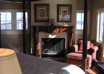 new gas fireplace in living room with white stone surround and wooden mantel