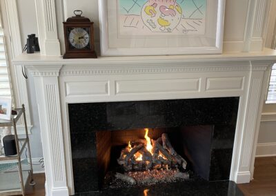 new gas fireplace in living room with white mantel and surround