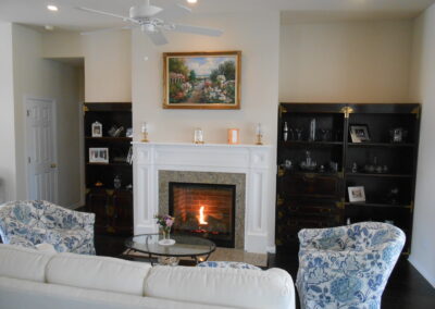 new gas fireplace in living room with white wooden mantel and surround