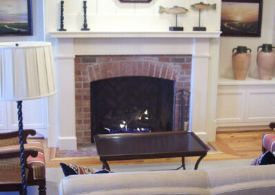new gas fireplace in living room with brick surround and white wood mantel