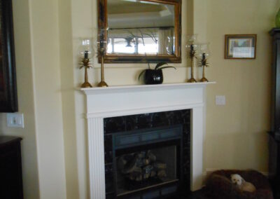 new gas fireplace in living room with white wood mantel and surround