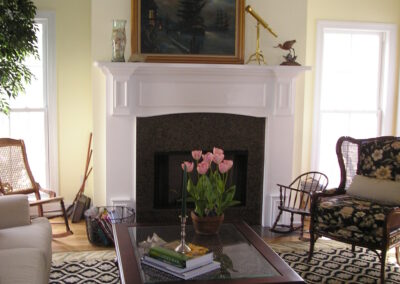 new gas fireplace in living room with white surround and mantel