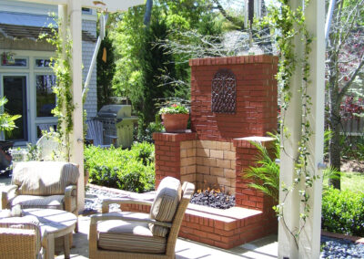 brick outdoor fireplace on back patio with furniture