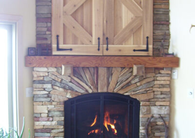 wood-burning fireplace with custom stone surround and wood doors